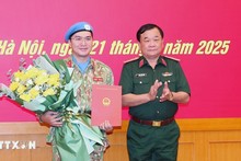Генерал-полковник Хоанг Суан Тьиен вручает решение майору Ши Тан Фи Лонгу. Фото: ВИА