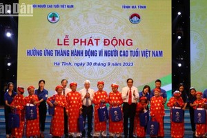 Товарищ До Ван Тьиен и Председатель Ассоциации пожилых людей Вьетнама Нгуен Тхань Бинь вручают подарки 100-летним людям в провинции Хатинь.