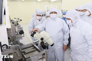 Премьер-министр Фам Минь Тьинь осматривает линию по производству полупроводниковых чипов в компании Hana Micro Vina. Фото: ВИА