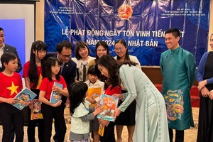 Заместитель министра иностранных дел Ле Тхи Тху Ханг вручает подарки детям на церемонии Дня вьетнамского языка в Японии 2024 года. Фото: МИД