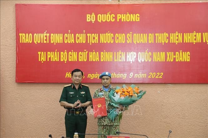 Генерал-полковник Хоанг Суан Тьиен вручает майору Буй Ван Нюнгу Решение Президента. Фото: VNA