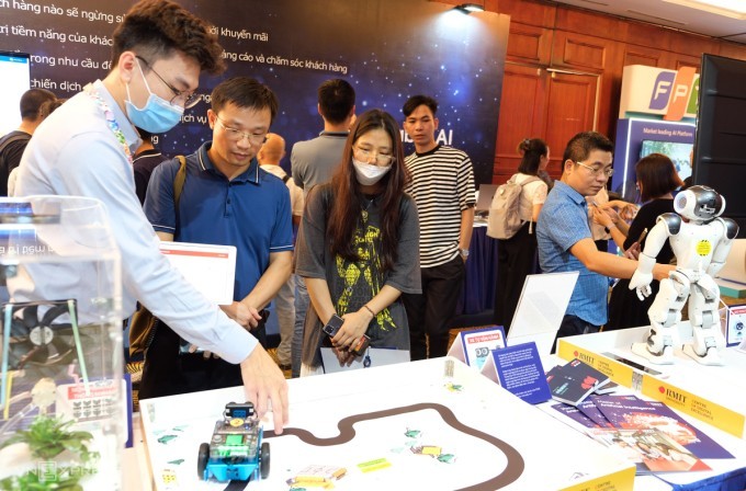 Молодые люди знакомятся с продуктами с использованием ИИ на фестивале искусственного интеллекта Вьетнама 2022 года. Фото: vsta.org.vn