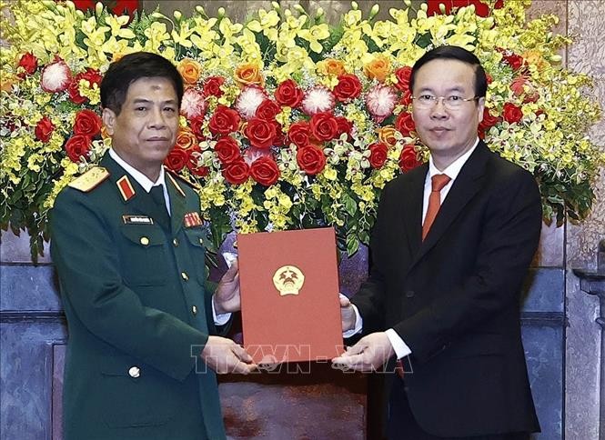 Президент Во Ван Тхыонг вручает решение о повышении в воинском звании с генерал-лейтенанта до генерал-полковника товарищу Нгуен Ван Нгиа. Фото: ВИА