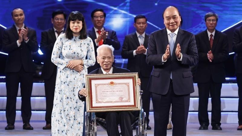 Президент Нгуен Суан Фук вручает премию им. Хо Ши Мина профессору, доктору наук Нгуен Куанг Хонгу. Фото: ВИА