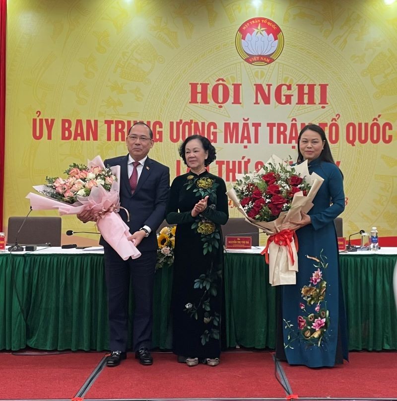 Товарищ Чыонг Тхи Май вручает цветы товарищам Нгуен Тхи Тху Ха и Хоанг Конг Тхюи.