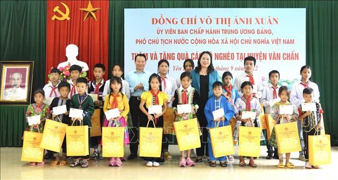 Вице-президент Во Тхи Ань Суан вручает подарки ученикам в уезде Вантьан. Фото: VNA