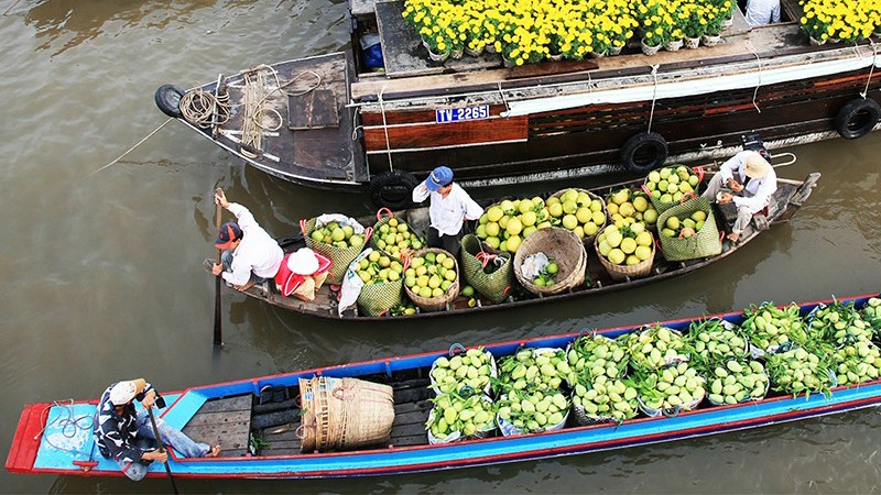 Торговля фруктами на плавучем рынке привлекает туристов. 