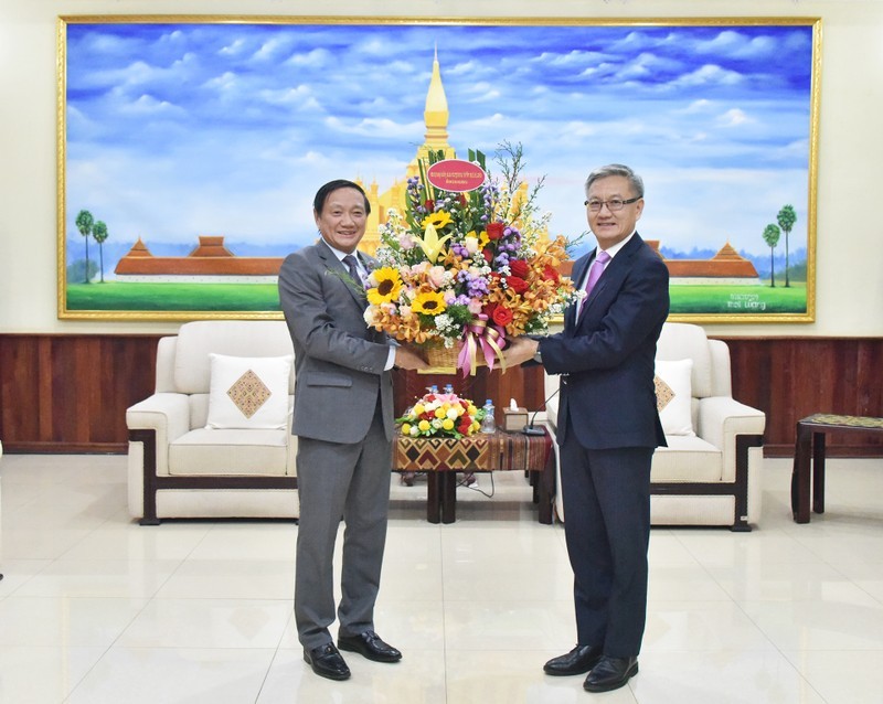 Посол Вьетнама в Лаосе Нгуен Ба Хунг поздравляет члена ЦК НРПЛ, Заведующего Отделом ЦК НРПЛ по внешним связям Тхонгсавана Фомвихана с 68-й годовщиной основания НРПЛ. Фото: Чинь Зунг