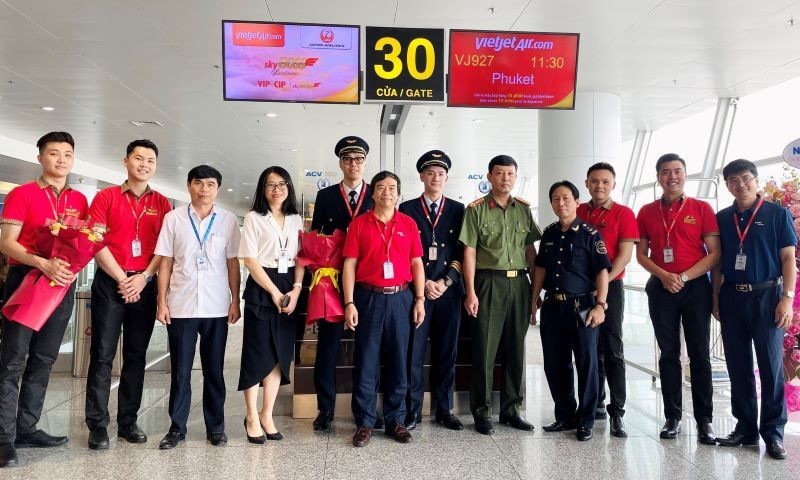Заместитель директора международного аэропорта Нойбай Дао Данг Тханг (третий слева) вручает цветы экипажу рейса VJ927. 