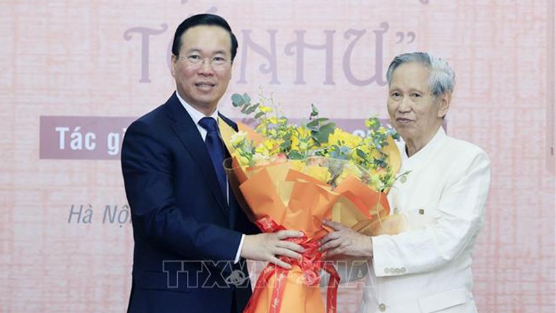 Президент Во Ван Тхыонг вручает цветы автору, писателю Во Ба Кыонгу. Фото: ВИА