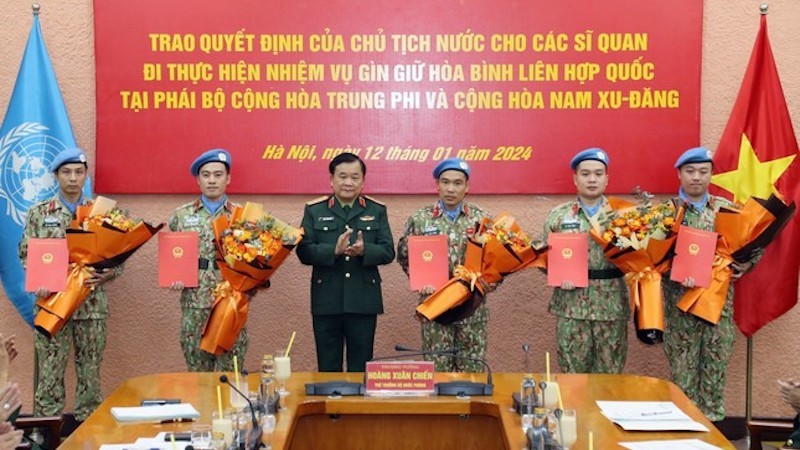 Генерал-полковник Хоанг Суан Тьиен вручает решения 5 офицерам.