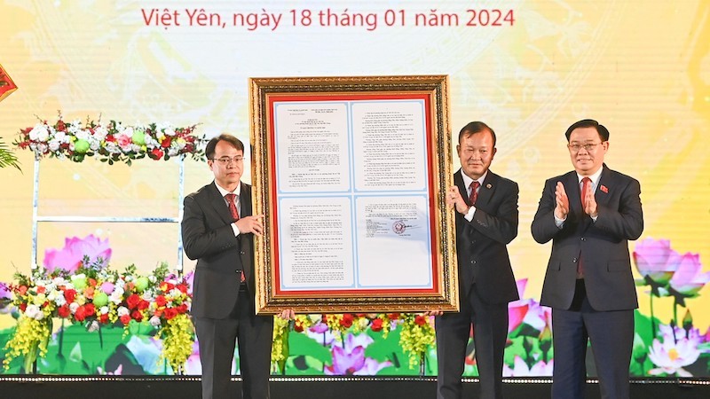 Председатель НС Выонг Динь Хюэ вручает Резолюцию руководителям уезда Вьетйен. Фото: Зюи Линь