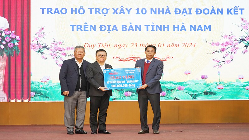 Руководители газеты «Нянзан» и Вьетнамской государственной нефтегазовой компании символически передают денежные средства для строительства домов великого единства представителю провинции Ханам.