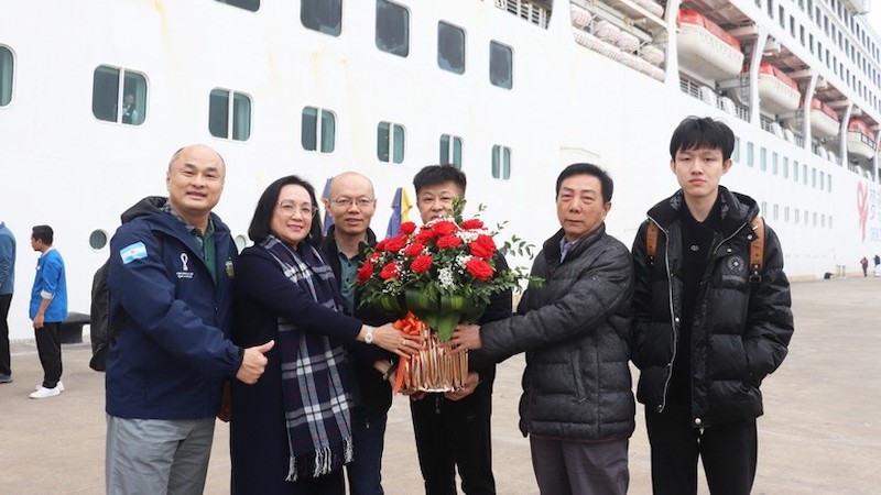 Руководитель Департамента туризма провинции Куангнинь дарит вручили цветы пассажирам круизного лайнера Dream Cruise. Фото: baoquangninh.vn