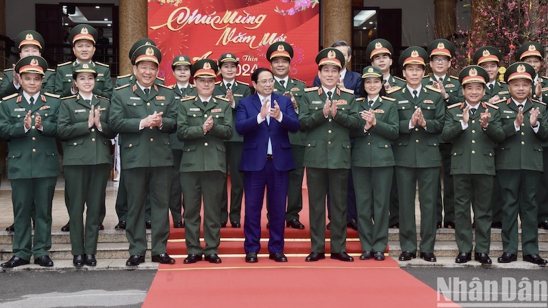Премьер-министр Фам Минь Тьинь и кадровые работники, преподаватели Военного университета культуры и искусств. Фото: Чан Хай