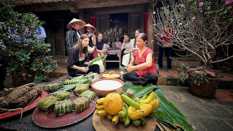 Иностранные гости знакомятся с приготовлением пирога «баньтьынг». Фото: ВИА