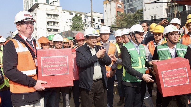 Премьер-министр Фам Минь Тьинь дарит подарки работникам, экспертам, рабочим, работающим на строительной площадке станции S12. Фото: Чан Хай