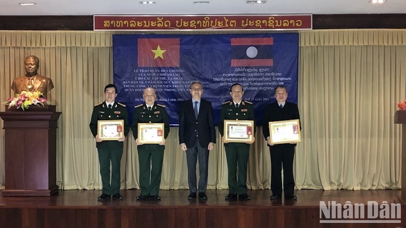 Товарищ Тхонгсаван Фомвихан вручает ордена и медали Лаоса коллективам и частным лицам медицинских учреждений Вьетнама.