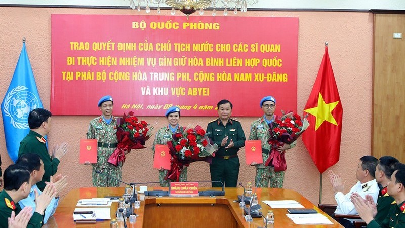 Генерал-полковник Хоанг Суан Тьиен вручает решения 3 офицерам.