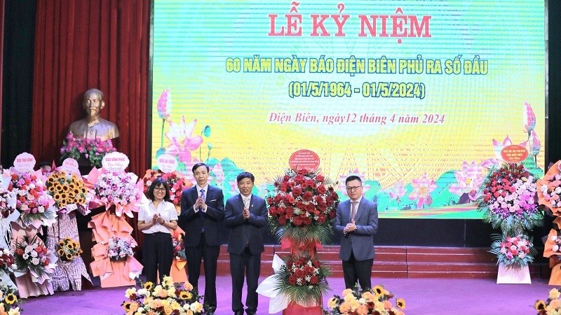Товарищ Ле Куок Минь вручает корзину цветов руководителям газеты «Дьенбьенфу».