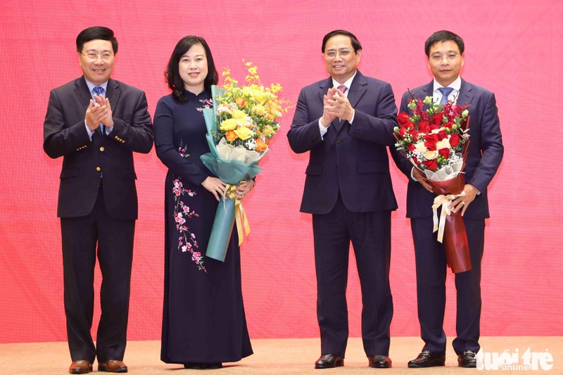 Премьер-министр Вьетнама Фам Минь Тьинь дарит цветы товарищам Дао Хонг Лан и Нгуен Ван Тхангу. Фото: tuoitre.vn