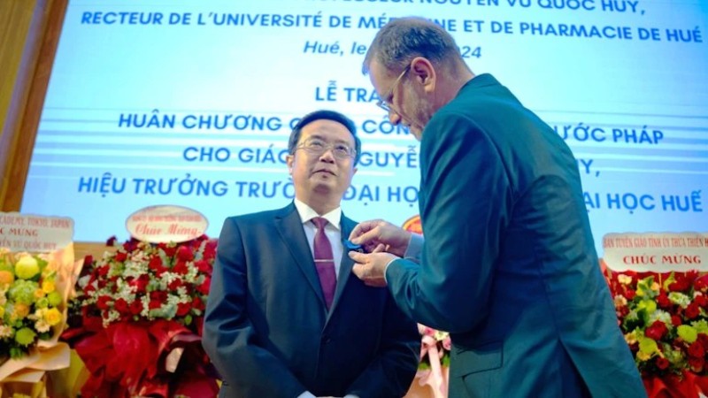 От имени Президента Франции Посол Франции во Вьетнаме Оливье Броше вручает Национальный орден «За заслуги» профессору Нгуен Ву Куок Хюи. 