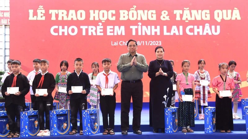 Премьер-министр Фам Минь Тьинь вручает подарки и стипендии ученикам. Фото: Чан Хай