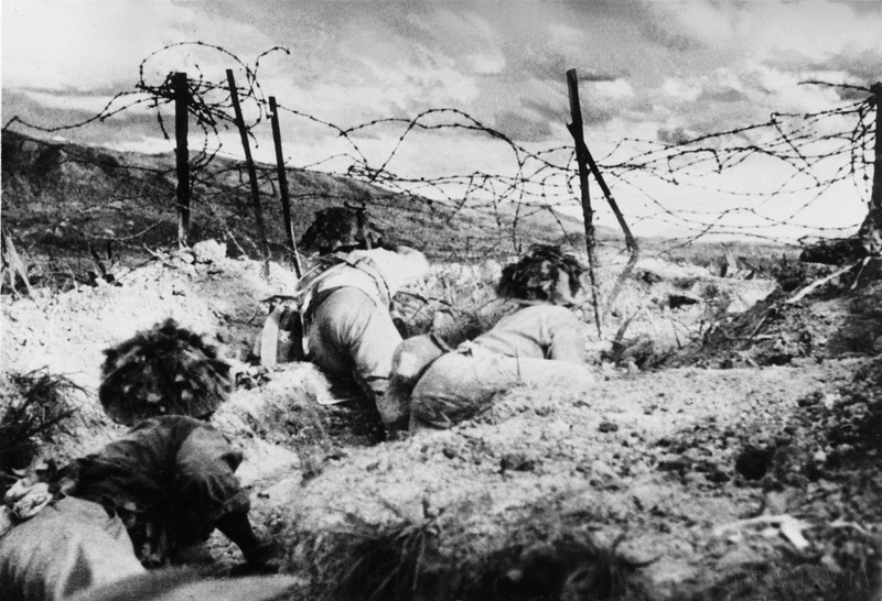 Наши солдаты перерезают заграждения из колючей проволоки, чтобы начать атаку на позиции противника в районе холма С. Фото: ВИА