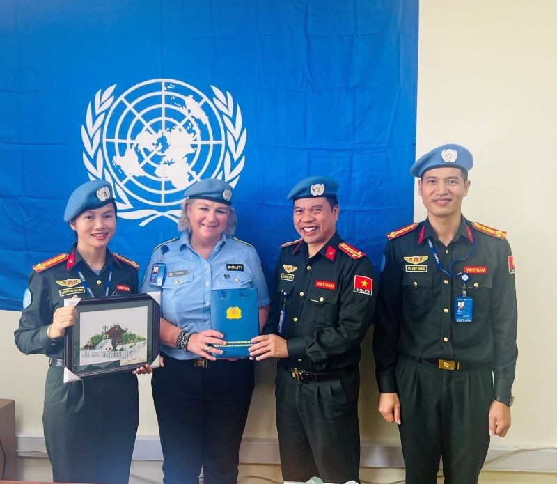 Г-жа Кристин Фоссен вручает похвальные грамоты трем офицерам Сил народной общественной безопасности Вьетнама.