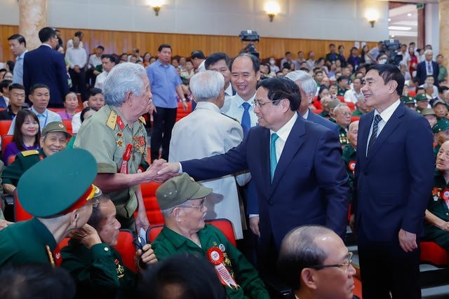 Премьер-министр Фам Минь Тьинь общается с ветеранами. Фото: Нят Бак