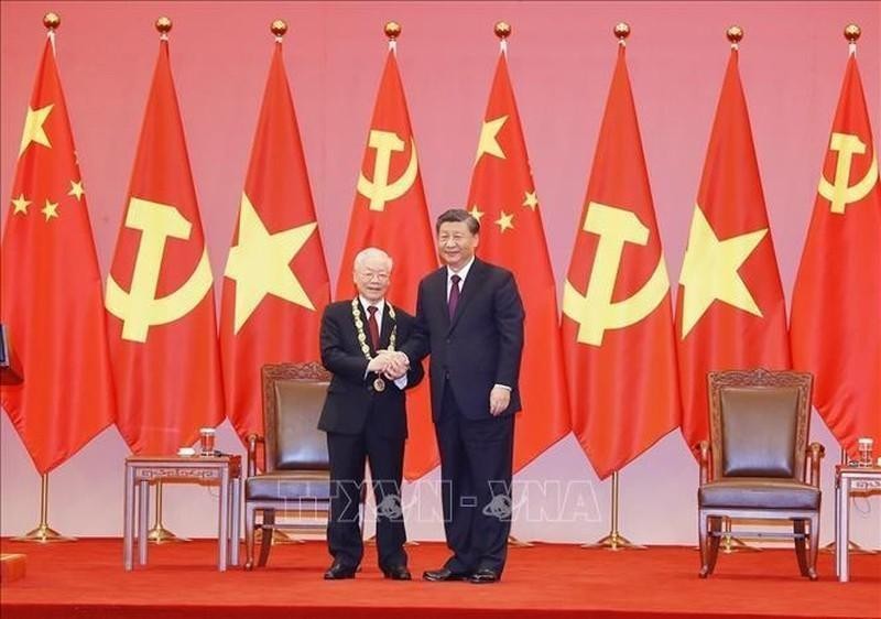 Генеральный секретарь ЦК КПК, Председатель КНР Си Цзиньпин вручает Орден Дружбы КНР Генеральному секретарю ЦК КПВ Нгуен Фу Чонгу. Фото: VNA
