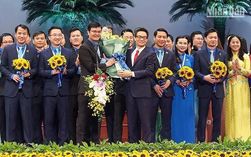 Вице-премьер Ву Дык Дам вручает цветы товарищу Буй Куанг Хюи и членам ЦК ВКСМ им Хо Ши Мина XII созыва.