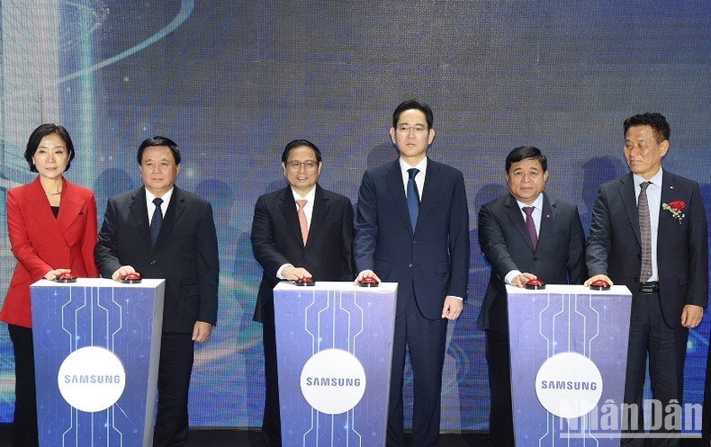 Премьер-министр Фам Минь Тьинь и делегаты нажимают кнопки в знак открытия Центра исследований и разработок «Samsung».