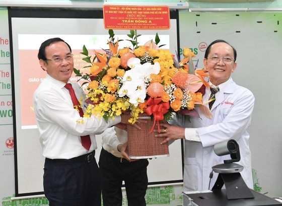 Товарищ Нгуен Ван Нэн вручает цветы профессору, доктору Чан Донг А. Фото: dangcongsan.vn
