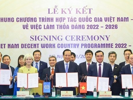 Представители МОТ и вьетнамских партнеров демонстрируют подписанную страновую программу достойного труда во Вьетнаме на 2022-2026 гг. Фото: qdnd.vn