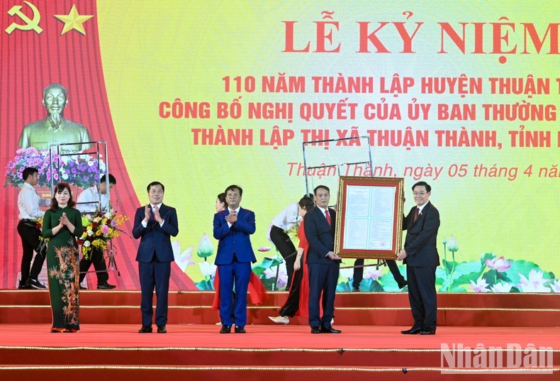 Председатель НС Выонг Динь Хюэ вручает Резолюцию Постоянного комитета НС руководителям городского уезда Тхуантхань. Фото: Зюи Линь