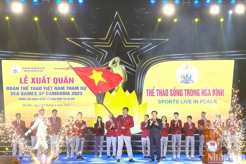 Вице-премьер Ле Минь Кхай вручает флаг главе спортивной делегации Вьетнама Данг Ха Вьету.
