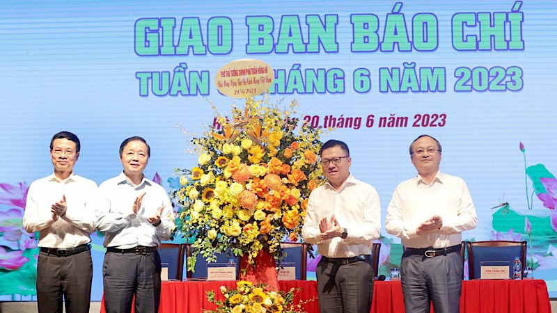 Вице-премьер Чан Хонг Ха (второй слева) вручает цветы представителям прессы по случаю 98-й годовщины Дня вьетнамской революционной прессы.