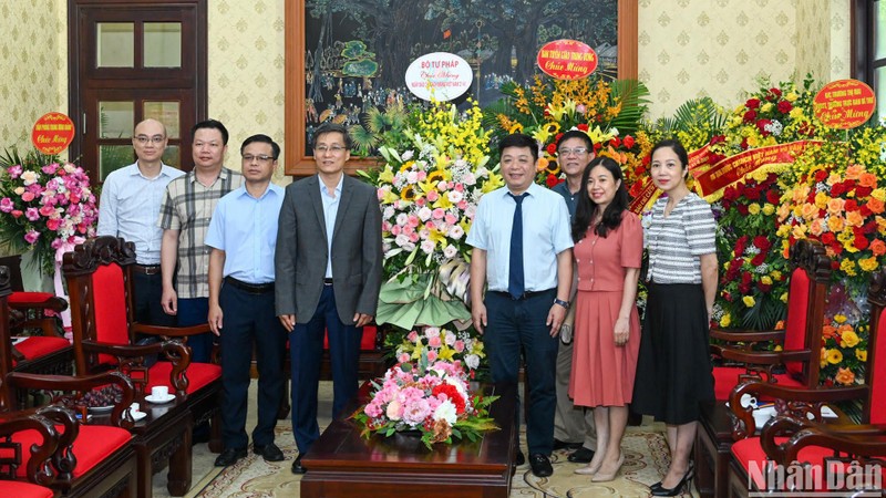 Заместитель министра юстиции Нгуен Кхань Нгок вручает цветы представителям газеты «Нянзан». Фото: Зюи Линь