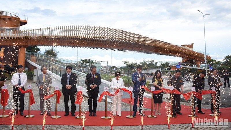 Делегаты разрезают ленту в знак открытия моста. Фото: Ань Дао