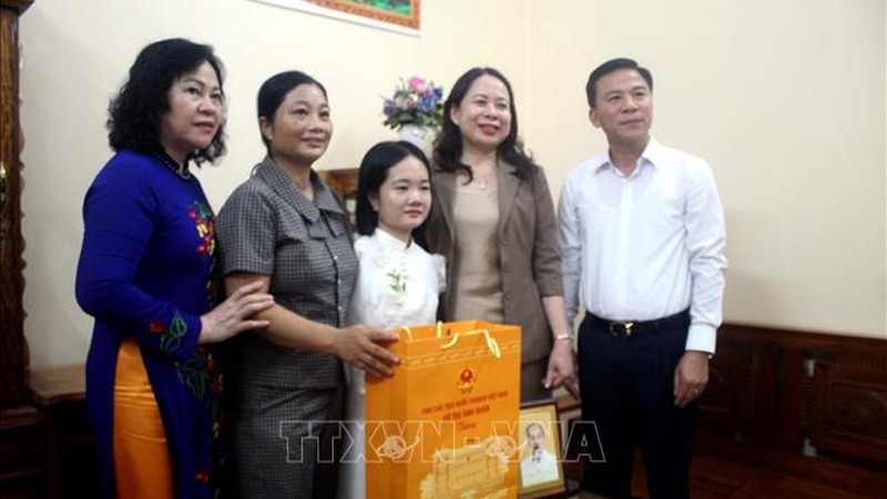 Вице-президент Во Тхи Ань Суан (вторая справа) вручает подарки учительнице Ле Тхи Тхам (в центре). Фото: ВИА