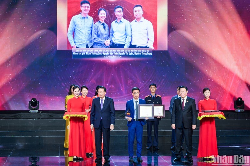Товарищи Выонг Динь Хюэ и Фан Динь Чак вручают приз А представителям группы авторов газеты «Нянзан».
