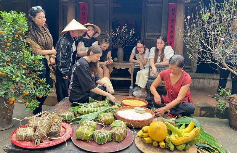 Иностранные гости участвуют в приготовлении пирогов «баньтьынг». Фото: ВИА