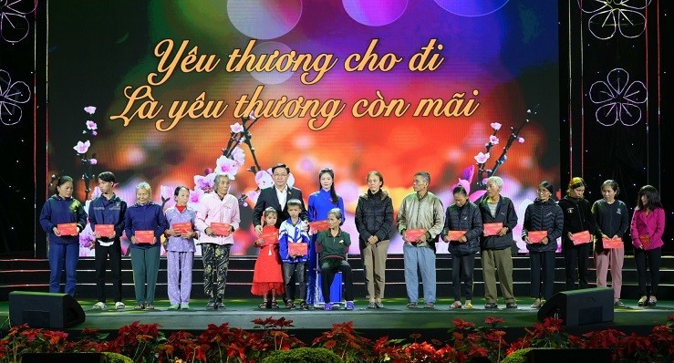 Председатель НС Выонг Динь Хюэ вручает подарки бедным домохозяйствам и семьям льготной категории.