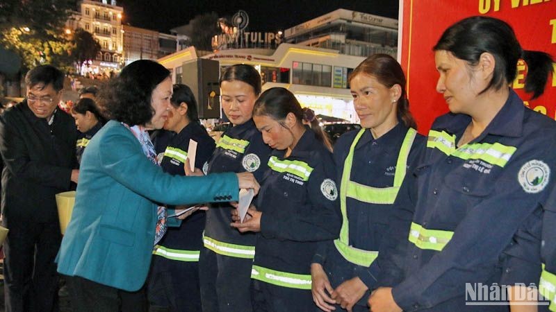 Товарищ Чыонг Тхи Май вручает рабочим подарки по случаю Нового года по лунному календарю.