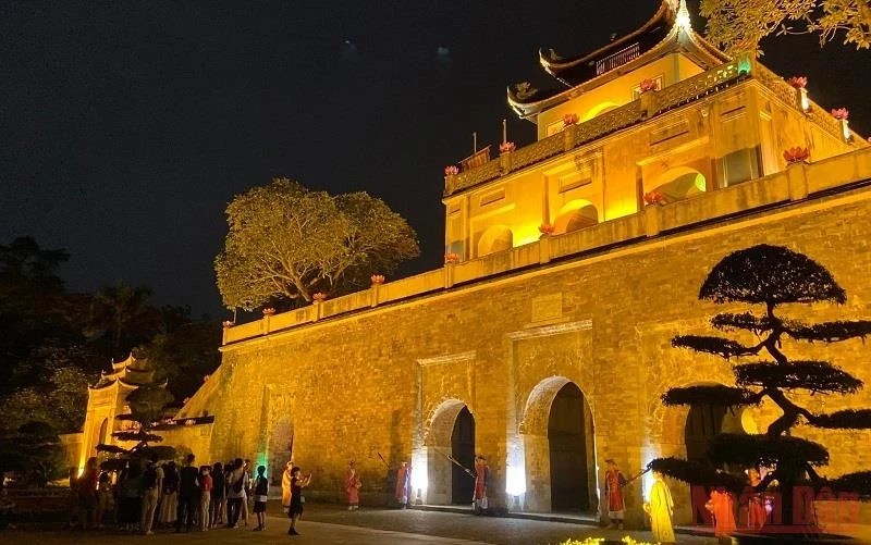 Туристы посещают Императорскую цитадель Тханлонг ночью.