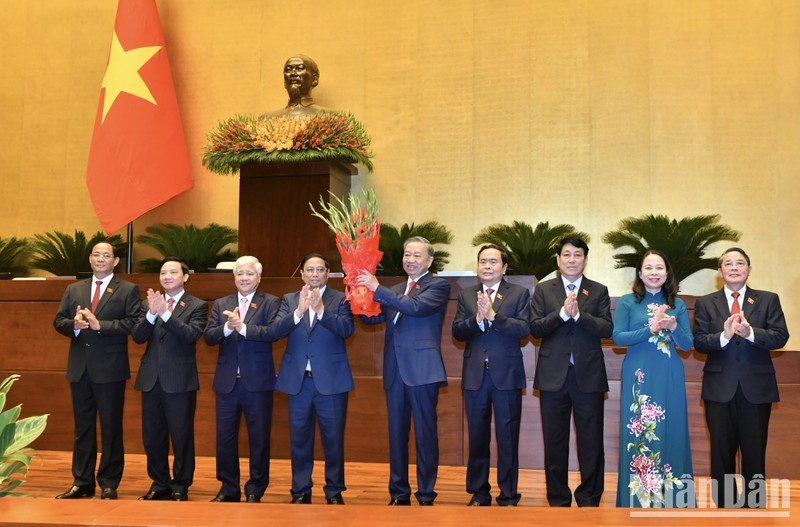 Руководители Партии и Государства вручают цветы Президенту То Ламу. Фото: Данг Кхоа