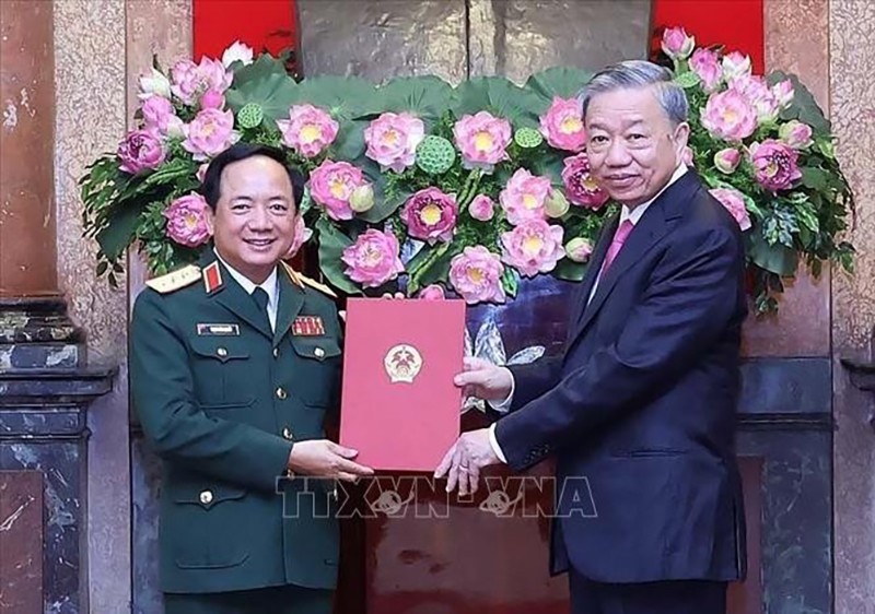 Президент То Лам вручает решение генерал-полковнику Чинь Ван Куету. Фото: ВИА