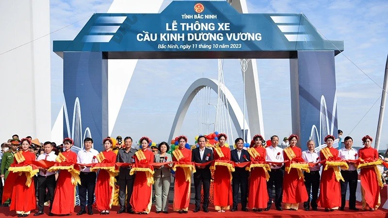 Делегаты разрезают ленту в знак открытия моста. Фото: Ан Чан 
