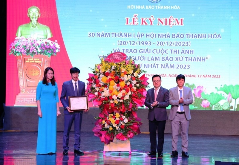 Товарищ Ле Куок Минь вручает Похвальную грамоту Союза журналистов Вьетнама и корзину цветов Ассоциации журналистов провинции Тханьхоа.
